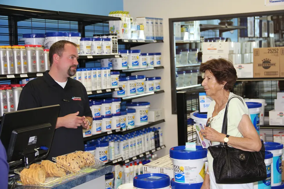 A Champion Pool and Spa Supply staff member helping a customer at the counter in Tucson